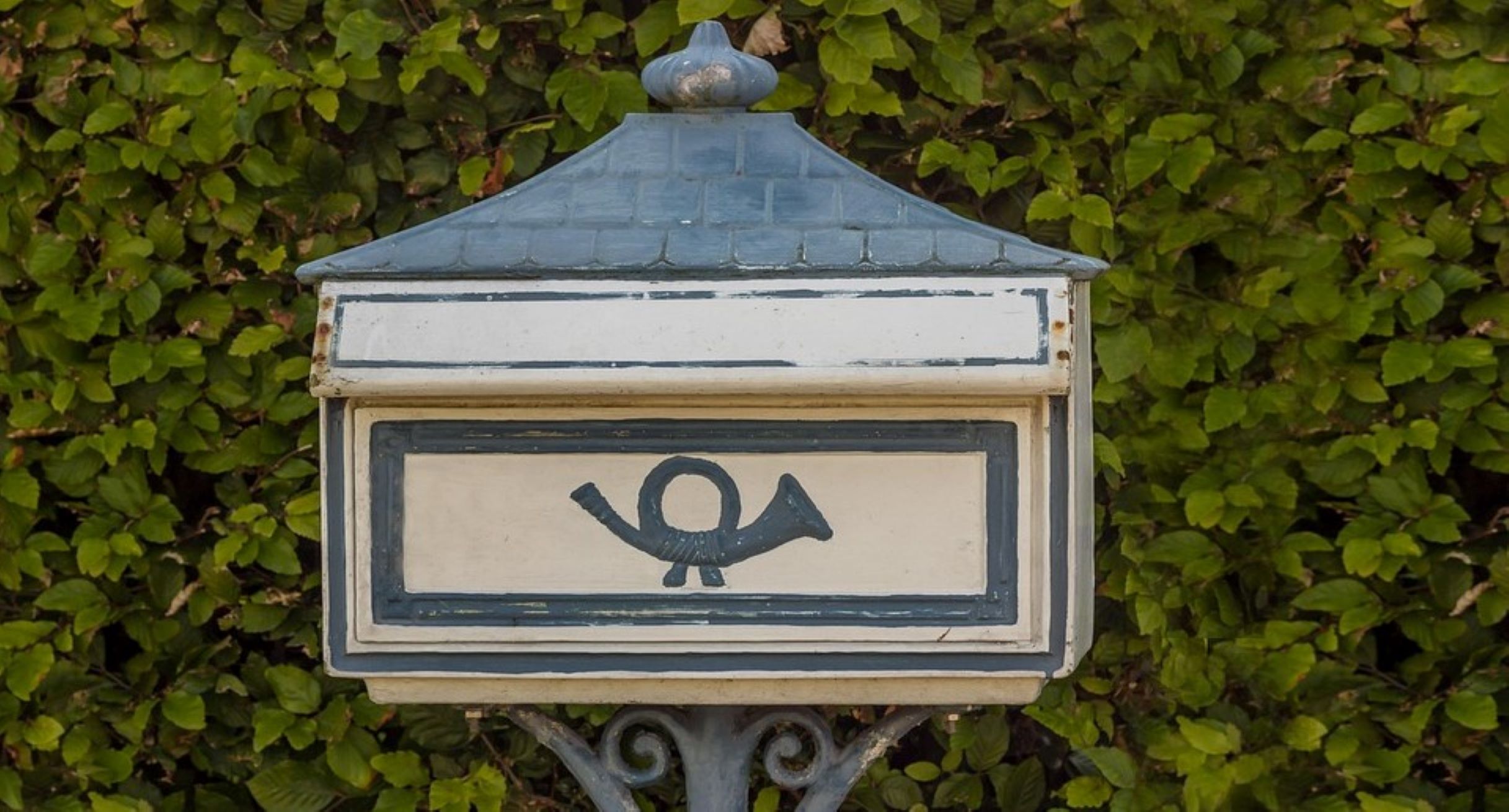 Briefkasten vor einer Hecke